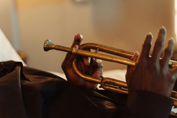 Artistic close-up of hands holding a brass trumpet, showcasing musical craftsmanship.