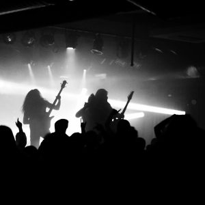 Captivating silhouette of a rock band performing live with an energetic crowd.