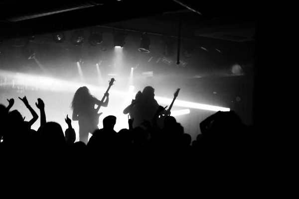 Captivating silhouette of a rock band performing live with an energetic crowd.